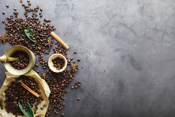 Egy zacskó kávé. Az asztalon sült kávébab. Kávébab főzésre szánt levelekkel. - Fotó, kép
