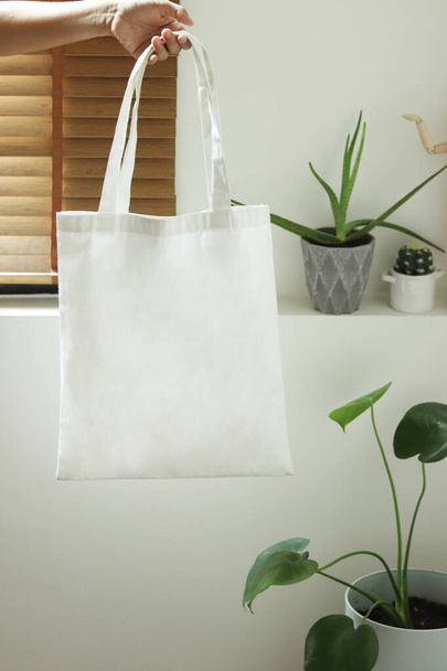 model hold blank white fabric tote bag for save environment on street fashion - Фото, зображення