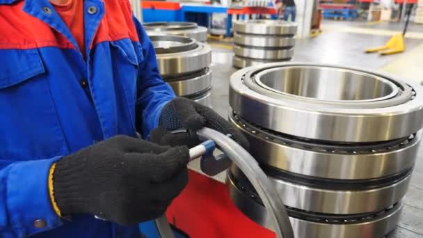 Bearing producing factory. Worker controlling technical characteristics of ready items. Machinery and industry concept. spare parts warehouse. Mechanic assembles bearings. 4 k video - Footage, Video