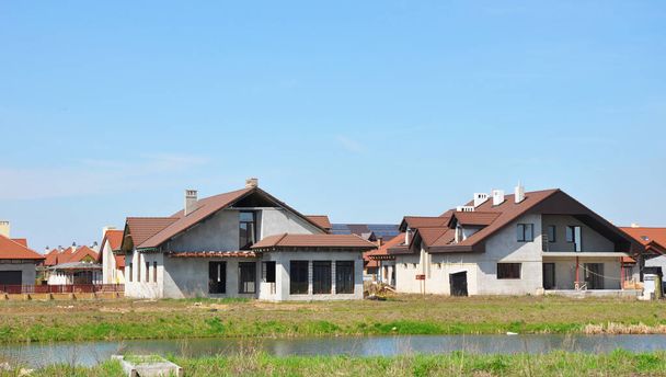 La construction de nouvelles maisons individuelles écoénergétiques dans une petite ville près de la rive de la rivière.  - Photo, image