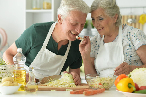 Senior couple cooking together at kitchen   - Фото, изображение