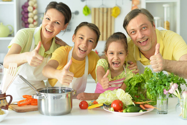 Cute family cooking together in kitchen showing thumbs up  - Zdjęcie, obraz