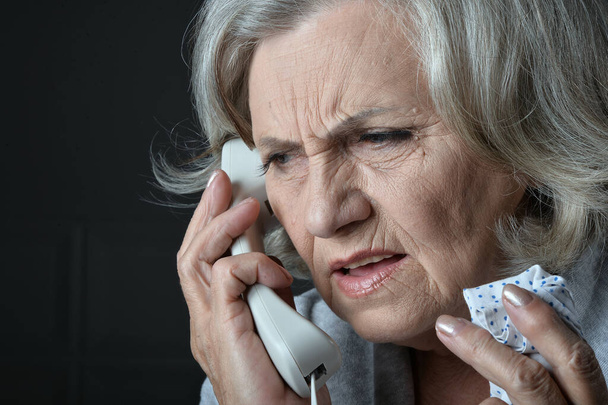 Close up portrait of ill senior woman calling doctor  - Photo, image