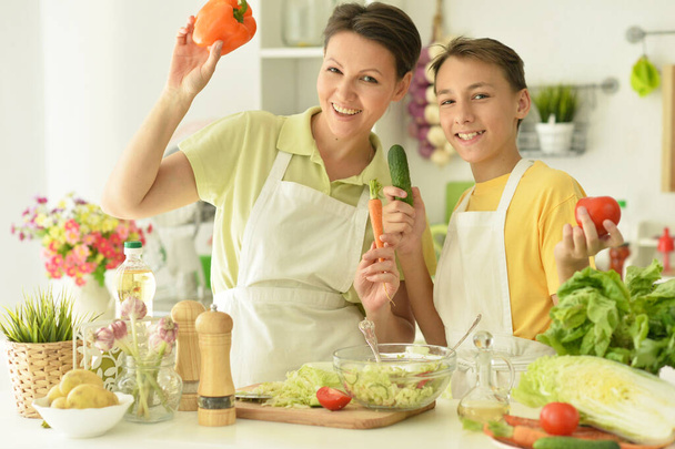 Mother and son making fresh salad at kitchen - Foto, Imagem