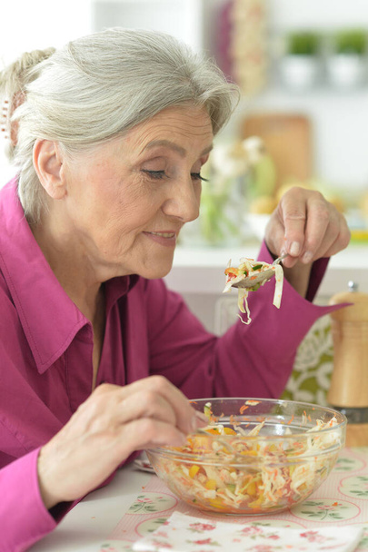 portrait of happy senior woman eating delicious salad  - 写真・画像