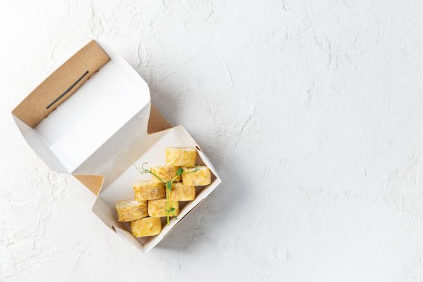 Sushi in a cardboard box on a light background. Horizontal orientation, copy space, top view. - 写真・画像