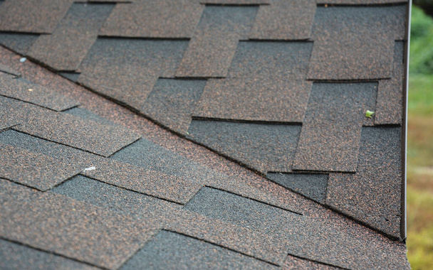 A close-up on the problem, critical area of a roof valley and drip edge covered with asphalt dimensional shingles above metal roof flashing.  - Photo, Image