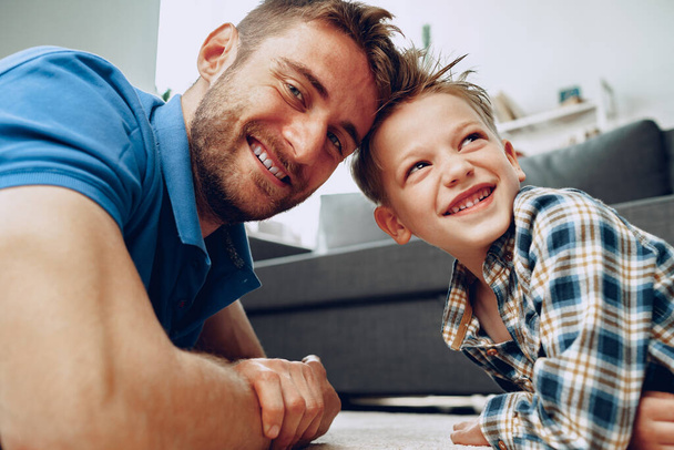 Padre e figlio giocano insieme sul tappeto a casa - Foto, immagini