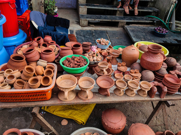 Πηλός λάμπες πετρελαίου, μικρές γλάστρες, βάζα, διατηρούνται στο χέρι καλάθι προς πώληση στην ινδική αγορά δρόμο - Φωτογραφία, εικόνα