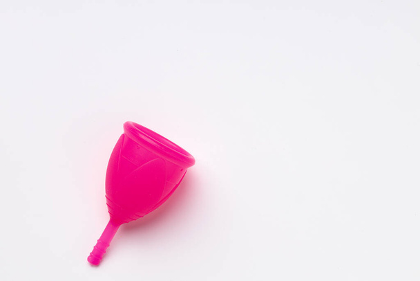 Pink silicone menstrual cup on white background - 写真・画像