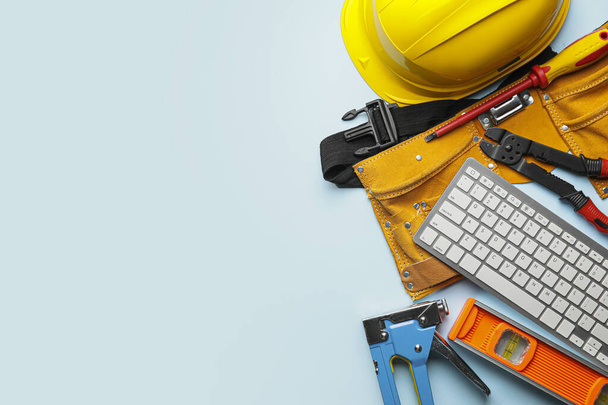 Construction tools and computer keyboard on color background - Fotó, kép