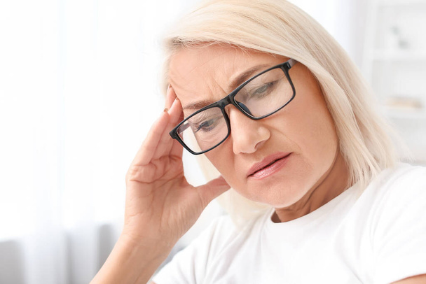 Gestresste reife Frau leidet unter Kopfschmerzen - Foto, Bild