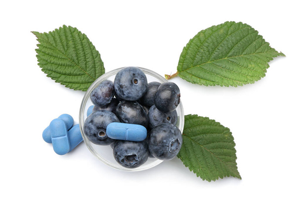 Bowl with plant based pills and blueberry on white background - Fotografie, Obrázek
