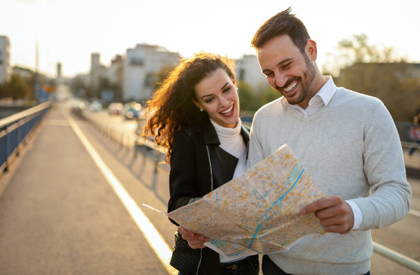 Happy couple tourists sightseeing city with map. People, travel, fun concept - Foto, Imagem