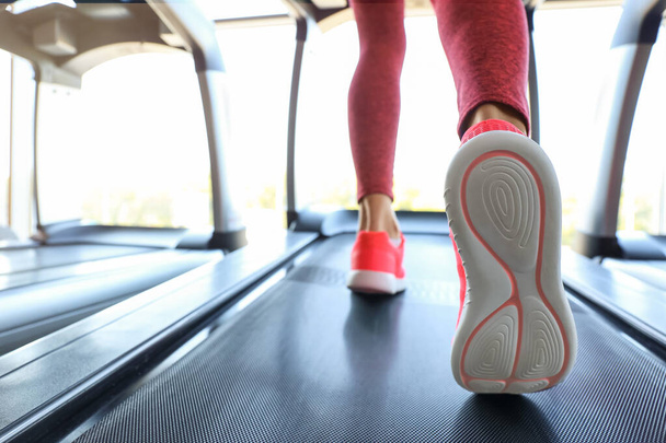 Woman training on treadmill in gym, closeup - Photo, Image