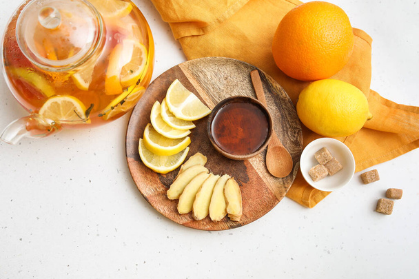 konvice a deska s citrónem, zázvorem a medem na stole - Fotografie, Obrázek