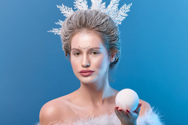 Zimowa piękność. Piękna Modelka Dziewczyna Z Fryzurą Śniegu I Makijaż. Świąteczny makijaż i manicure. Zimowa królowa ze śniegiem i fryzurą na lodzie - Zdjęcie, obraz