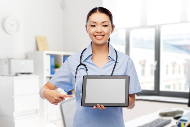 asian female nurse with tablet pc at hospital - Photo, Image