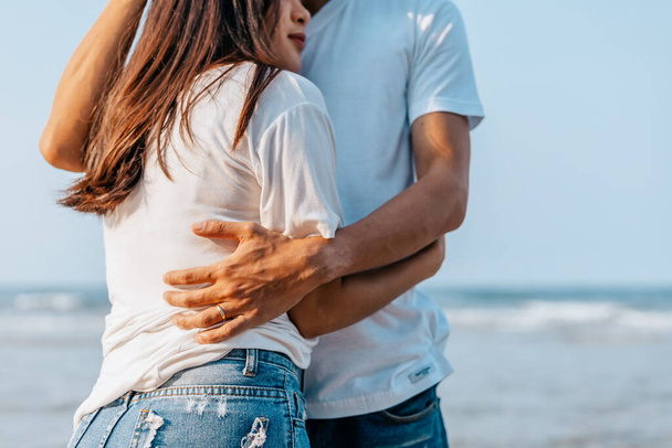 romantic couple hug together on the beach at summer. Honeymoon, travel, holiday, summer concept.  - Photo, image