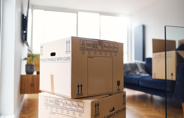 Gros plan des boîtes de déménagement empilées dans le salon prêtes à emménager ou à quitter la maison - Photo, image