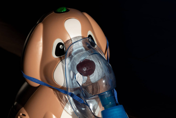 Een inhalator in de vorm van een hondje. Geschikt voor volwassenen en kinderen. Compressor vernevelaar. - Foto, afbeelding