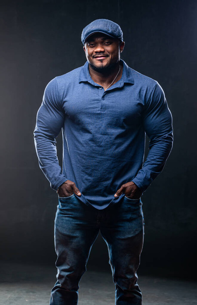 Professional african american sportsman posing on camera in casual clothes. Black studio background. - Photo, image