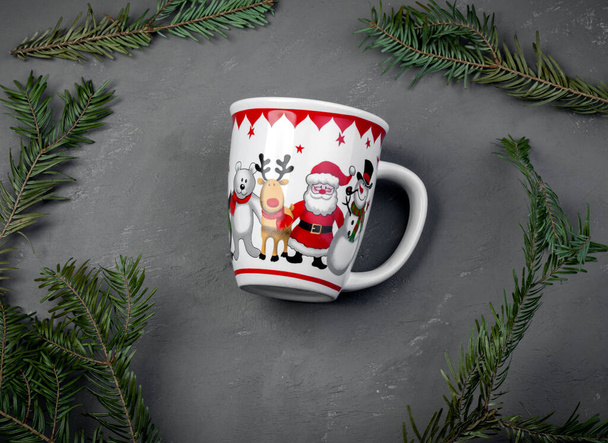 White cup with the image of a deer, santa on a gray background among the fir branches - Foto, imagen