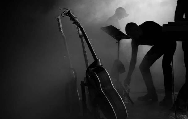 ομιχλώδης σκηνή με κιθάρες και μουσικούς λίγο πριν την έναρξη της παράστασης - Ασπρόμαυρο - Φωτογραφία, εικόνα