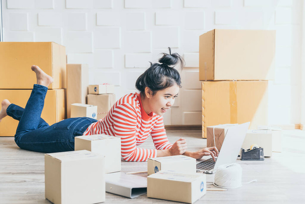 Asian Women business owner working at home with packing box on workplace - online shopping SME entrepreneur or online selling concept - Foto, imagen