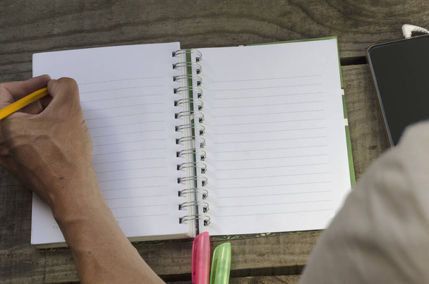 молодий чоловік пише на ноутбуці з олівцем для мобільних телефонів та висококласниками, ліворуч записує ідеї або натхнення
 - Фото, зображення
