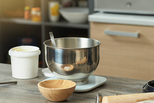 Home kitchen table with mixer bowl, wooden bowls, flour and desserts decorating attachments. Preparing to prepare the cream. - Foto, immagini