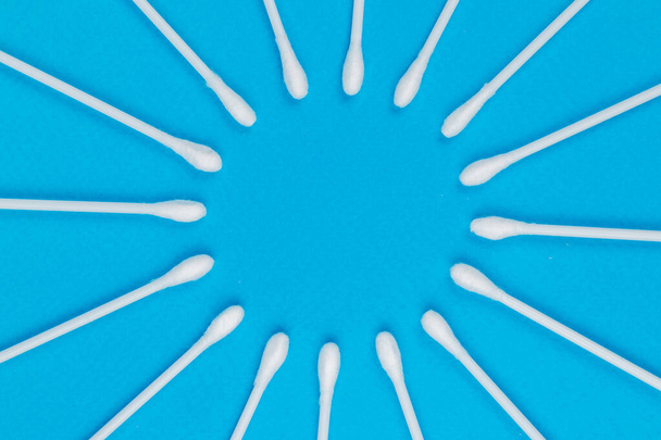 Mavi arkaplanda beyaz pamuklu çubuklar - Fotoğraf, Görsel