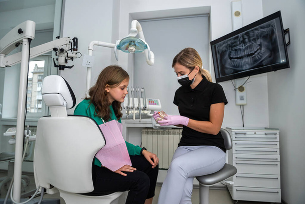 Dentysta pokazuje jak myć zęby od modelu szczęki do pacjenta w klinice stomatologicznej. opieki zdrowotnej - Zdjęcie, obraz