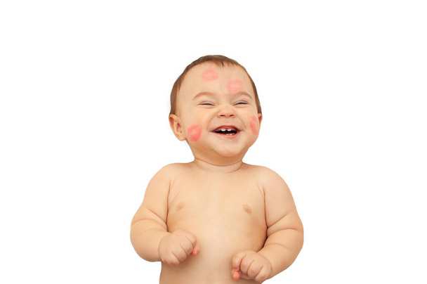 šťastné dítě políbilo červenou rtěnkou v otiscích. leží se širokým úsměvem na bílém izolovaném pozadí - Fotografie, Obrázek