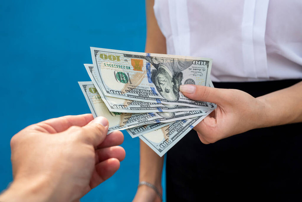 Geschäftsfrau mit Dollars auf blauem Grund. Finanzierungskonzept - Foto, Bild