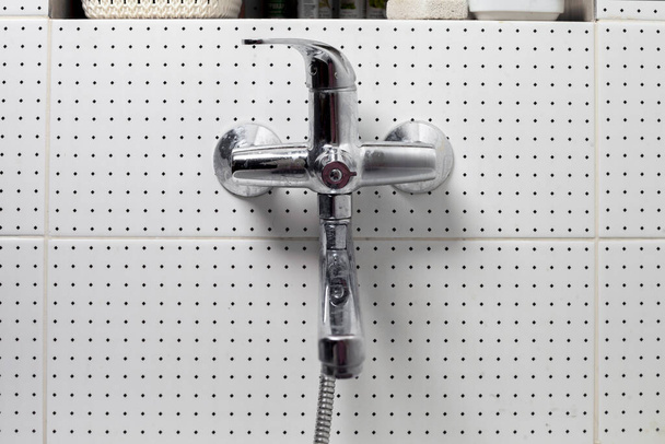 modern wall-mounted bathroom mixer with adjustable water temperature. chrome-plated water faucet on ceramic tiles - Photo, Image