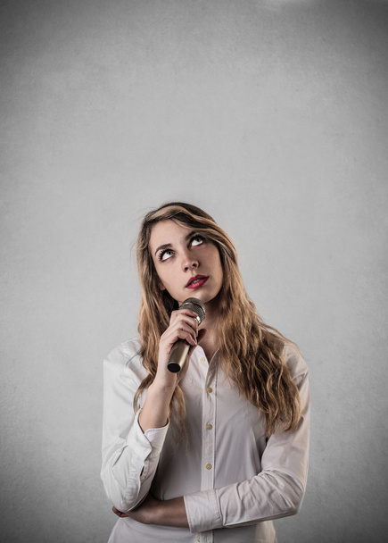 bir mikrofon aracılığıyla konuşan genç kadın - Fotoğraf, Görsel