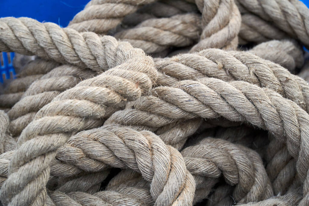 Довгі товсті коричневі мотузки в синьому кошику
 - Фото, зображення