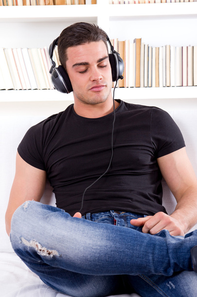 man relaxing in sofa with headphones on - Photo, Image