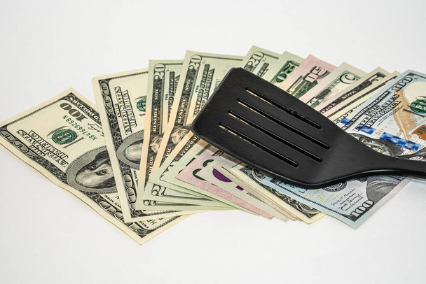 Spatule de cuisine en plastique noir sur dollars américains - Photo, image