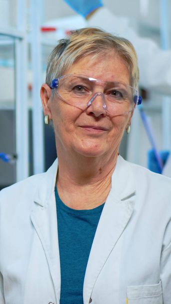 Portret van een oudere wetenschapper vrouw glimlachend op de camera - Foto, afbeelding