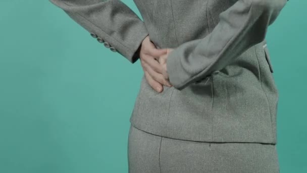 Backache. Lower Back Pain. Unhealthy business woman in working suit touching injured back. suffering lower lumbar discomfort. muscle pain overwork. isolated blue green background. Healthcare concept - Footage, Video