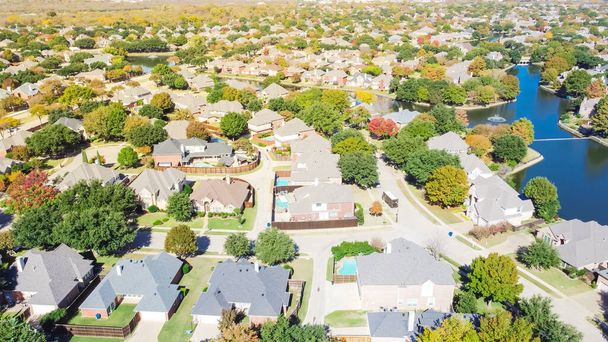 Top uitzicht luxe huizen aan het water omgeven door kleurrijke herfst gebladerte in Coppell, Texas, Amerika. Luchtfoto uitzicht buurt meer met kleine dam en fontein - Foto, afbeelding