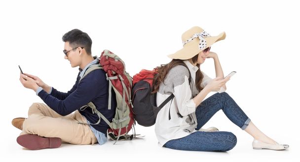 Aasian nuori pari matkustaa ja käyttää matkapuhelinta
 - Valokuva, kuva