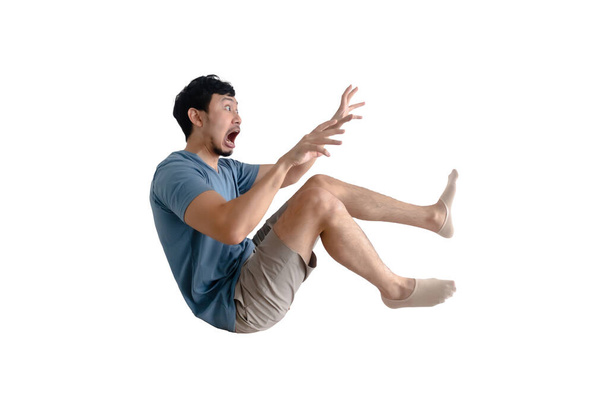 Full body of shocked Asian man being blown away on isolated background. - Foto, Imagem
