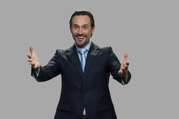 Happy excited businessman on gray background. - Foto, afbeelding