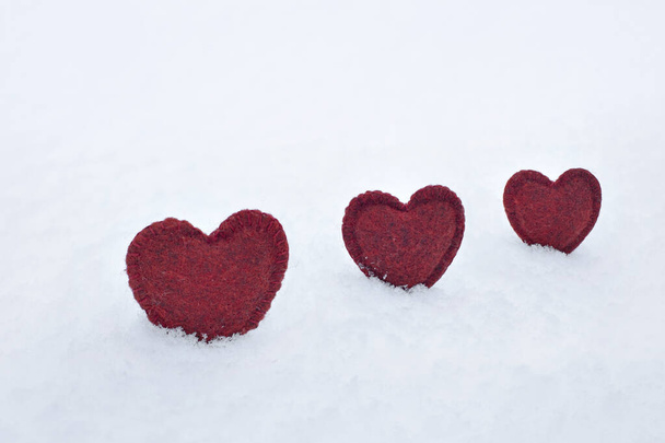 red homemade woolen hearts on white fluffy snow in winter, concept of love, valentine's day, first snow, i love winter, free space for text, - Photo, image