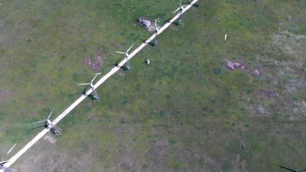 Des éoliennes et une route sur un champ vert. Vidéo de drone filmant à partir d'une vue aérienne - Séquence, vidéo