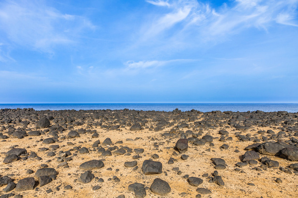 Сухая зона со старыми камнями лавы на побережье
  - Фото, изображение