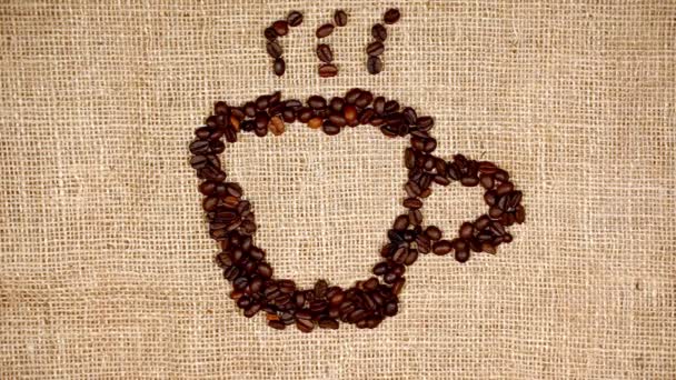 Roasted coffee beans arranged in the form of coffee cup logo. - Footage, Video